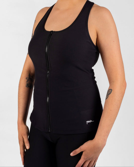 Person wearing a black sleeveless top with a zipper on a white background