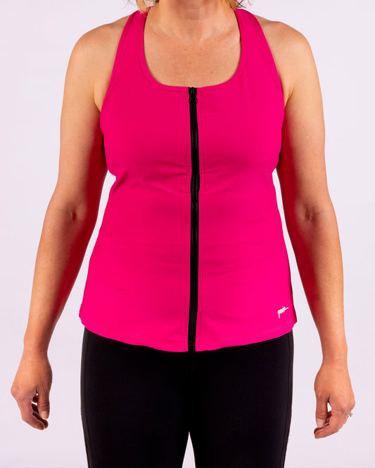 Woman wearing a bright pink sleeveless top with a black zipper on a white background
